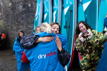 people hugging in dryrobes