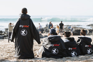 Kids at Surfers Not Street Children (SNSC) at J Bay wearing dryrobes on the beach