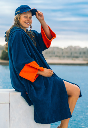 Female wearing deep sea blue dryrobe zip towel robe by outdoor pool
