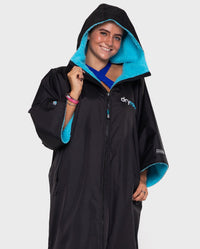 1|Woman wearing Black Blue dryrobe® Advance Short Sleeve with hood up