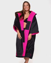 1|Woman wearing Black Pink dryrobe® Advance Short Sleeve unzipped
