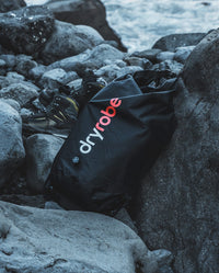 dryrobe® Compression Travel Bag on rocks on the beach