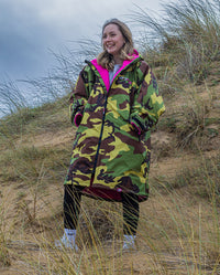 1|Girl stood in sand dunes wearing Camo Pink dryrobe® Advance Kids Long Sleeve