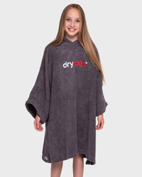 Girl smiling wearing Kids Towel Poncho in Slate Grey with hood down