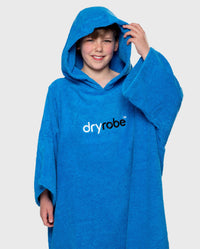 Boy wearing Cobalt Blue Kids Organic Towel poncho with hood up