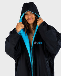 1|*MALE* wearing Black Blue dryrobe® Advance Long Sleeve with hood up