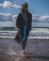 1|*MALE* walking out of the sea, wearing Black Blue dryrobe® Advance Long Sleeve