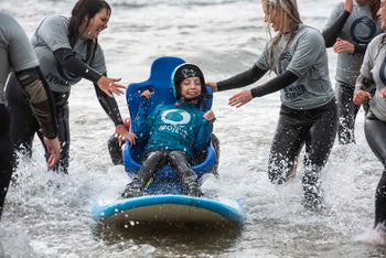 Wave Project volunteers surfing with adaptive athlete