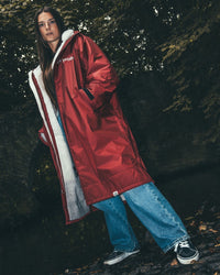 Female standing by stream and bridge  wearing AW25 Burgundy Dryrobe® advance long sleeve 