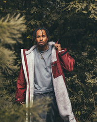 *MALE* standing by trees wearing AW25 Burgundy Dryrobe® advance long sleeve 