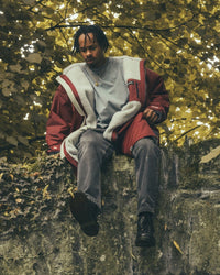 *MALE* sitting on countryside bridge wearing AW25 Burgundy Dryrobe® advance long sleeve 