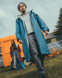 *MALE* outside on a field wearing AW25 Blue Dryrobe® advance long sleeve 
