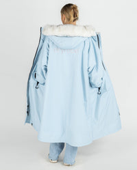 Woman facing away from camera, wearing dryrobe Advance Long Sleeve Alpine Range change robe in Alpine Ice Blue