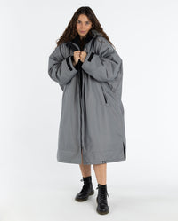 Woman wearing dryrobe Advance Long Sleeve Alpine Range change robe in Alpine Graphite holding collar together 