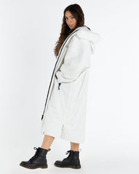 Woman stepping to the side, wearing dryrobe Advance Long Sleeve Alpine Range change robe in Alpine White 
