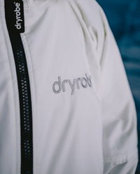 Close-up of logo on dryrobe Advance Long Sleeve Alpine Range change robe in Alpine White
