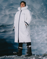 Man stood in ice cave, wearing dryrobe Advance Long Sleeve Alpine Range change robe in Alpine White
with hood down