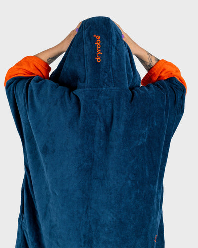 Female in studio wearing Dryrobe® Zip towel (blue orange)