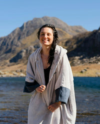 Adult female by water wearing Dryrobe® Zip towel (nimbus cloud)