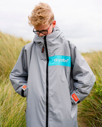 Child on sand dunes wearing LTD edition 2025 RNLI Dryrobe® Advance long sleeve