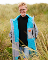 Child walking on sand dunes wearing LTD edition 2025 RNLI Dryrobe® Advance long sleeve