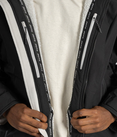 *MALE* Close-up of a person wearing a black zip-front jacket with a white sherpa lining and white zipper tape printed with the brand name 'pedalo'.