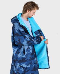 **MALE** Man wearing dryrobe Advance Long Sleeve changing poncho in Blue Camo Blue showing the inner lining and internal pocket