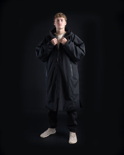*MALE* Person wearing a long black Dryrobe Nexus on a black background
