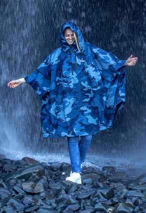 female stood in front of waterfall wearing waterproof poncho