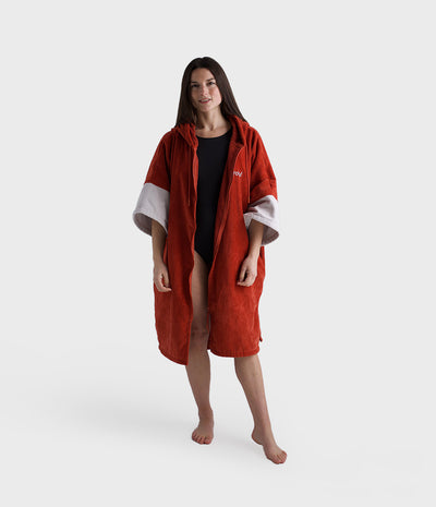 Person wearing a red hooded towel on a white background