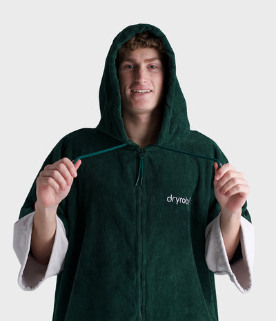 *MALE* Person wearing a green hooded robe with 'dryrobe' branding on a white background