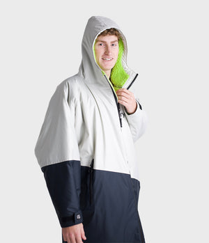 *MALE* Person wearing a Dryrobe holding a green cleaning tool on a white background