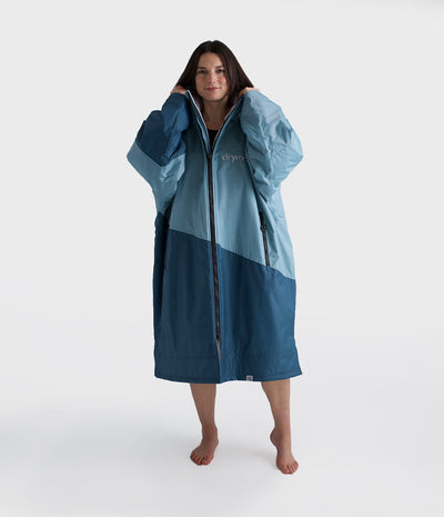 Woman wearing a blue and navy Dryrobe on a white background