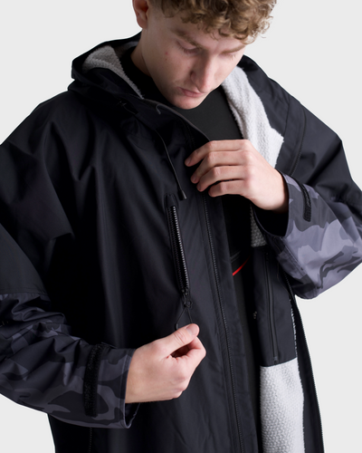 *MALE*Person wearing a black and camouflage jacket on a white background