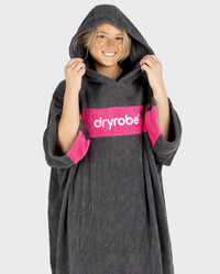 Woman smiling wearing Organic Towel dryrobe Remix in Slate Grey Pink with hood up