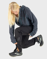 Woman kneeling down, doing up zip on leg of dryrobe® Thermal Trousers