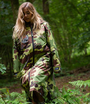 Person wearing a Dryrobe® camouflage change robe in a forest setting