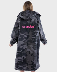 Woman with back to the camera wearing dryrobe Advance Long Sleeve REMIX Range change poncho in Black Camo Pink Black