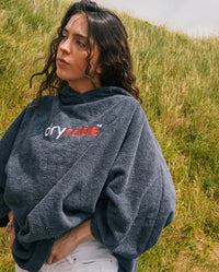 Close up of woman standing in sand dunes, wearing Slate Grey Organic Towel dryrobe®