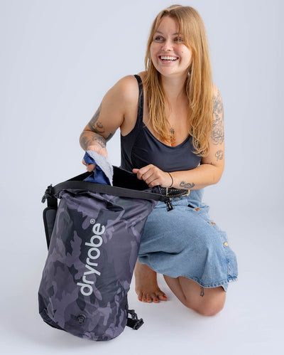 Woman in studio unpacking black camo Dryrobe® compression bag 
