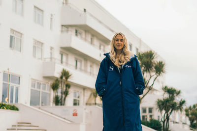Person wearing a blue customised Dryrobe® changing robe by Saunton Sands hotel