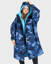 Woman wearing dryrobe Advance Long Sleeve change poncho in Blue Camo Blue with hood up 