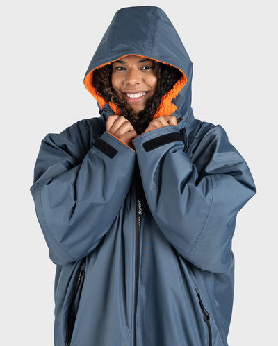 Woman wearing dryrobe Advance Long Sleeve change robe in Dark Grey Orange with hood up 