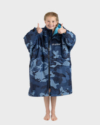 Girl wearing dryrobe Advance Long Sleeve Changing poncho in Blue Camo Blue with zip up holding both thumbs up 