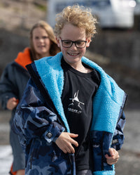 Kids running towards camera, wearing dryrobe Advance Long Sleeve Changing ponchos