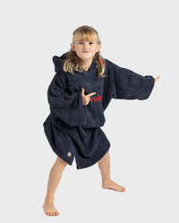 Girl wearing Organic Towel dryrobe in Navy pointing fingers to the right