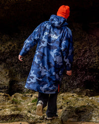 **MALE** Man with back to the camera wearing Blue Camo Orange dryrobe advance long sleeve changing robe and orange dryrobe beanie