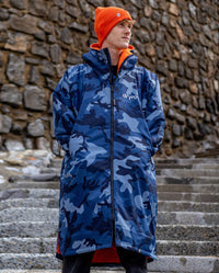 **MALE** Man stood on steps wearing Blue Camo Orange dryrobe advance long sleeve changing robe and orange dryrobe beanie