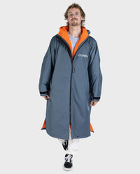 **MALE** Man walking toward the camera, wearing dryrobe Advance Long Sleeve change poncho in Dark Grey Orange 