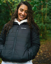 Woman stood in forest smiling, wearing dryrobe Mid-layer Jacket in Black 